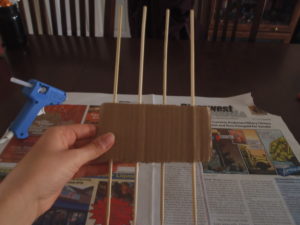 1.Take a chunk of cardboard (the nice thick stuff with the holes in the sides rather than the thin stuff from food boxes) and stick four skewers through the sides. The spacing between the skewers will determine how big your bow is. (Big space = big bow, little space = little bow). Play around with spacing to determine your preference. It’s easy to switch it up.
